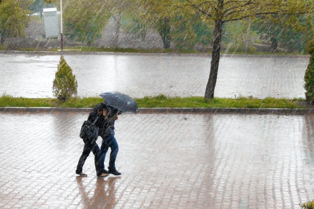couple walking in street while raining