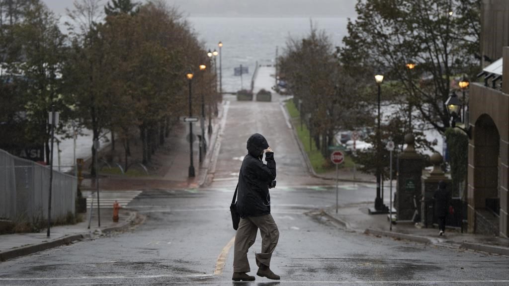 A pedestrian shields themselves from rain