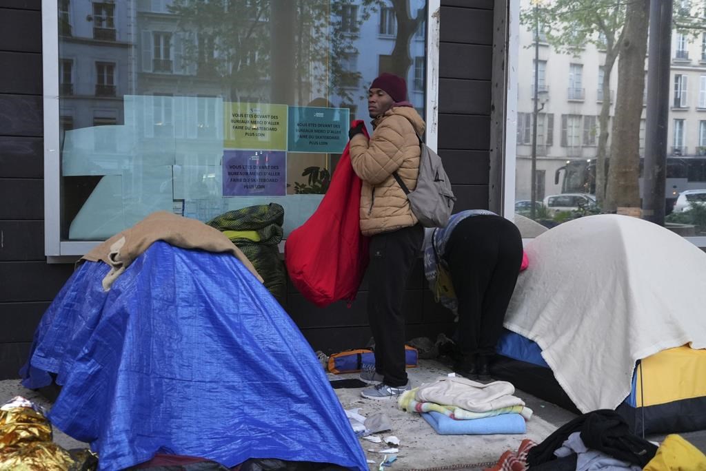 Police clear out a migrant camp in central Paris. Activists say it's a pre-Olympics sweep