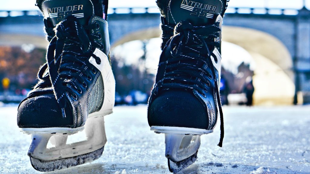 close-up photo of black-and-gray Intruder ice skates on frozen body of water