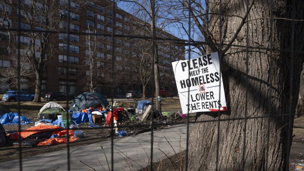 homeless is seen through a fenced-in homeless encampment