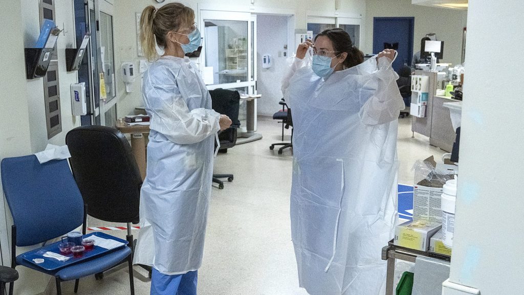 Nurses put on their gowns as they prepare to attend patients in the intensive care ward at the Halifax Infirmary in Halifax