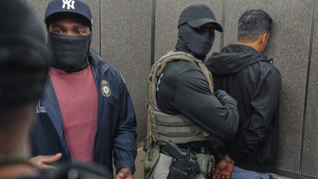 FILE - Immigration and Customs Enforcement agents escort a detained immigrant into an elevator after he exited an immigration courtroom, Tuesday, June 17, 2025, in New York. (AP Photo/Olga Fedorova, file)